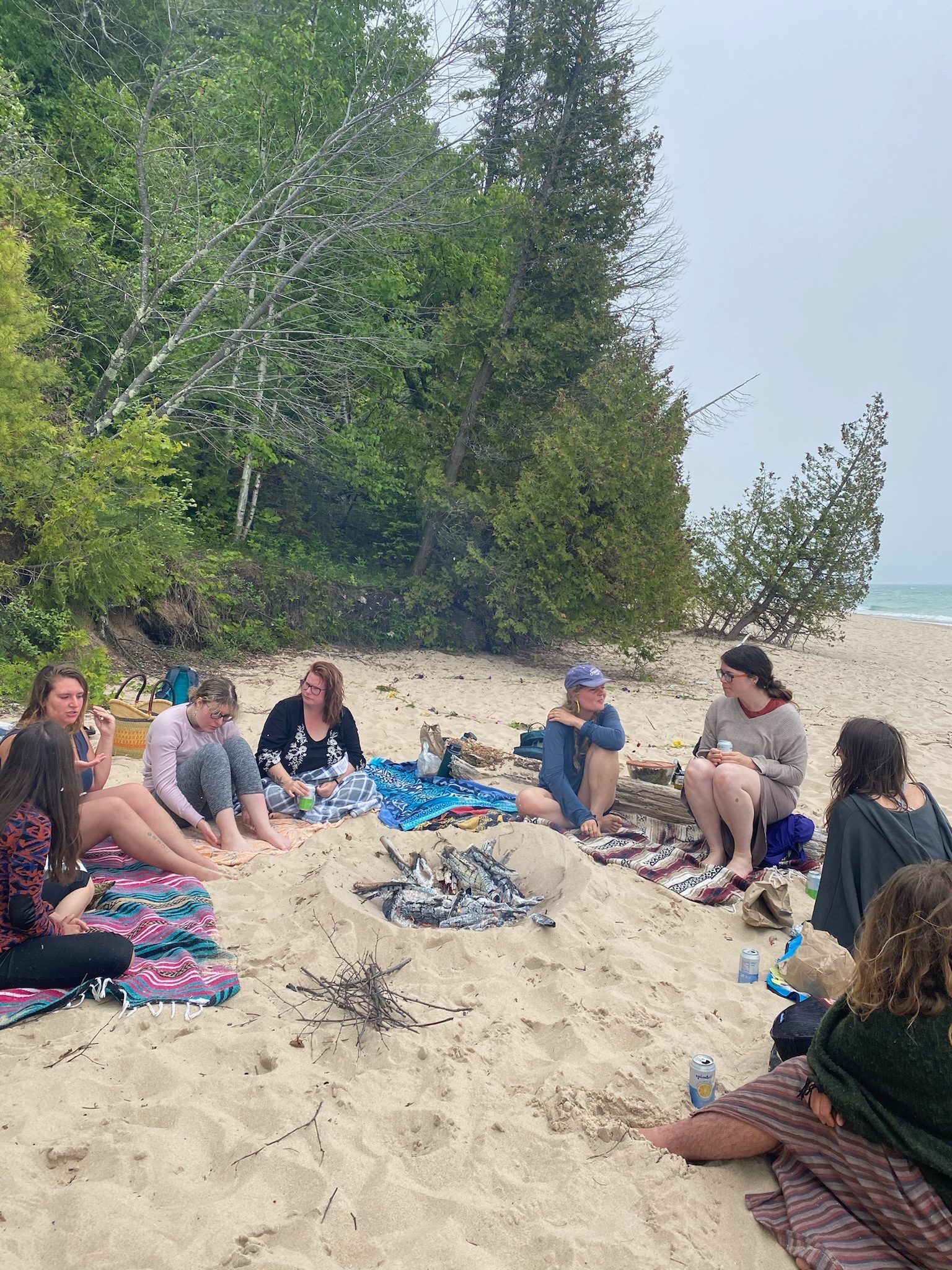 Retreat group gathered around a campfire on the beach