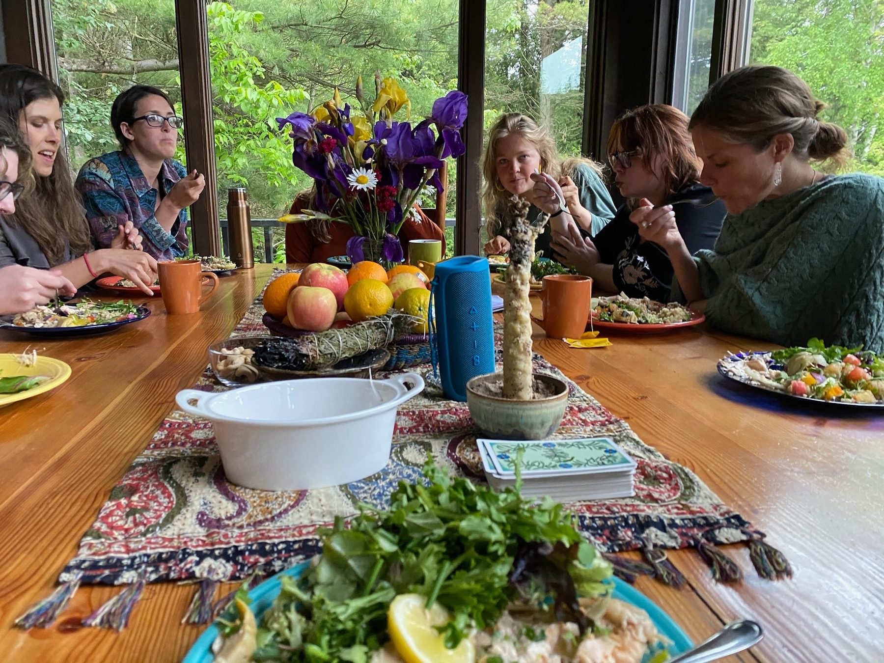 Retreat guests sharing a meal together at a table with fresh flowers